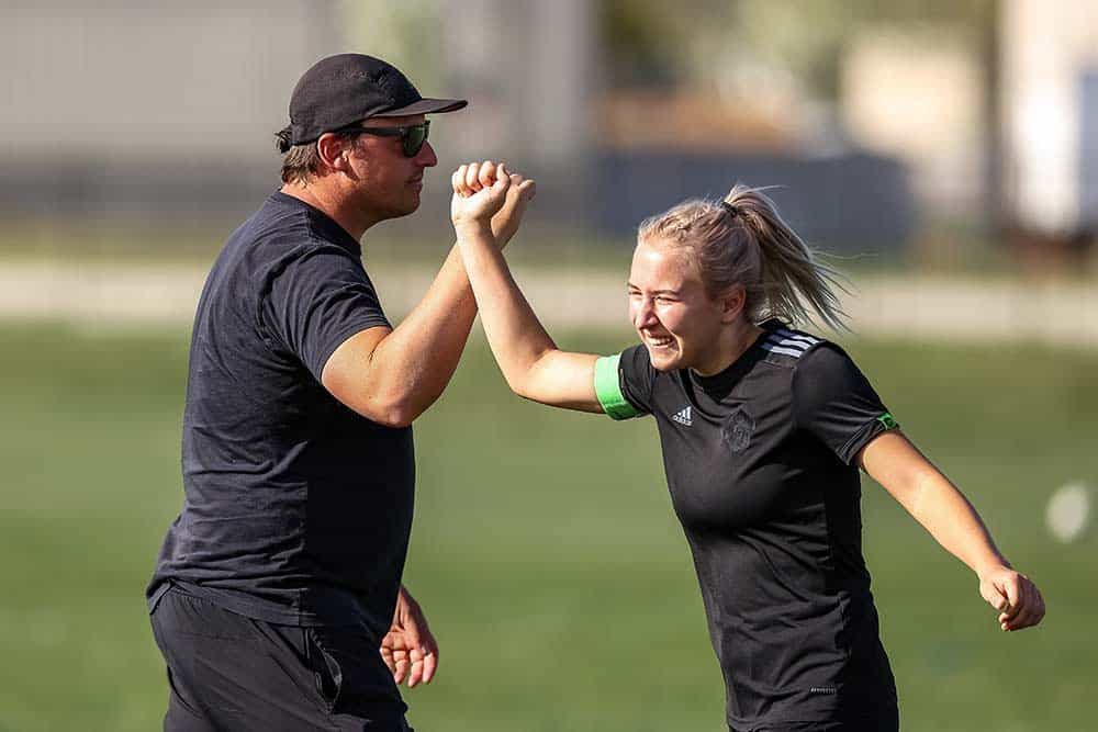 Coach and player celebrating with a fist bump